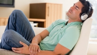 Man relaxing on couch with headphones
