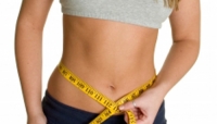 Skinny lady with tape measure around tummy